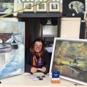 Jan on the Art Boat peering through the side hatch between two paintings